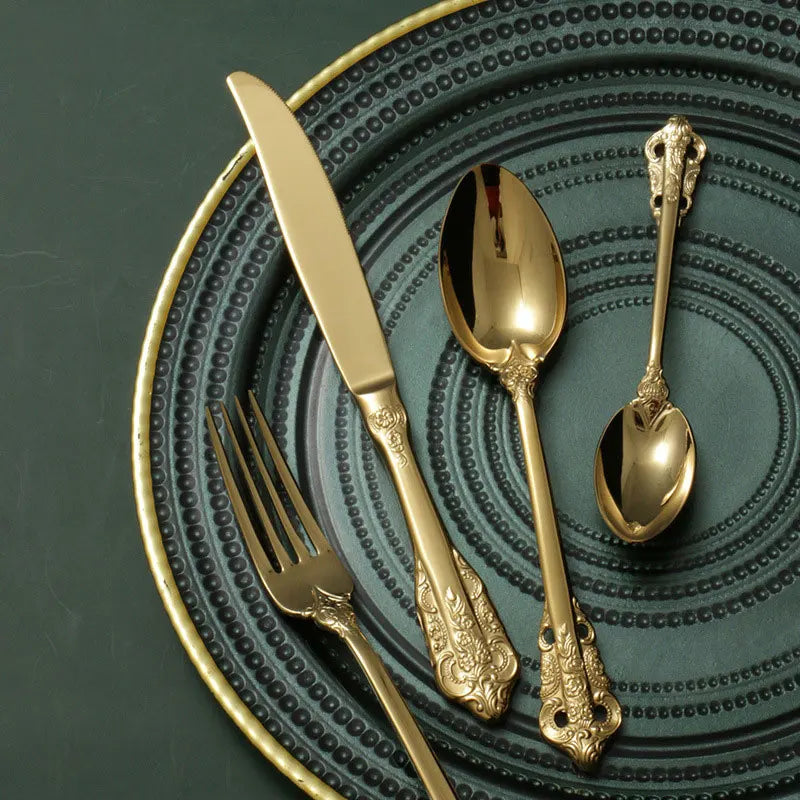 Goldenes Besteckset im Barock Design auf dekorativem Teller – Edelstahl Luxus Besteck elegant gedeckter Tisch